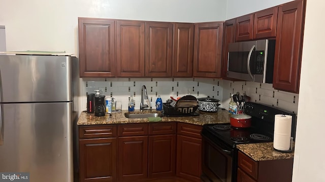 kitchen with stainless steel appliances, sink, backsplash, and stone counters