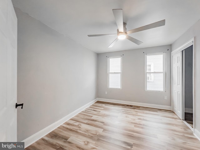 unfurnished bedroom featuring ceiling fan, light hardwood / wood-style floors, and a closet