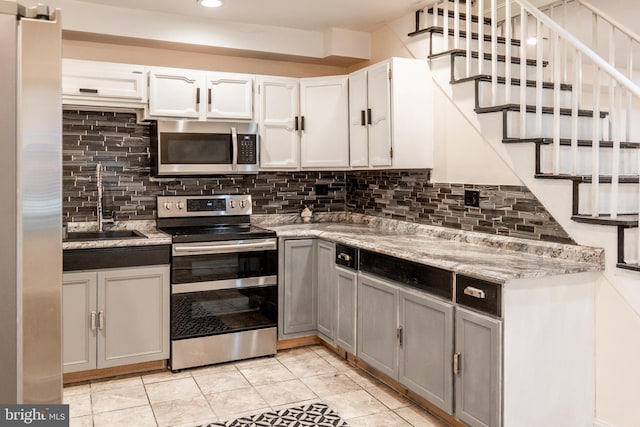 kitchen with gray cabinetry, sink, white cabinetry, and appliances with stainless steel finishes