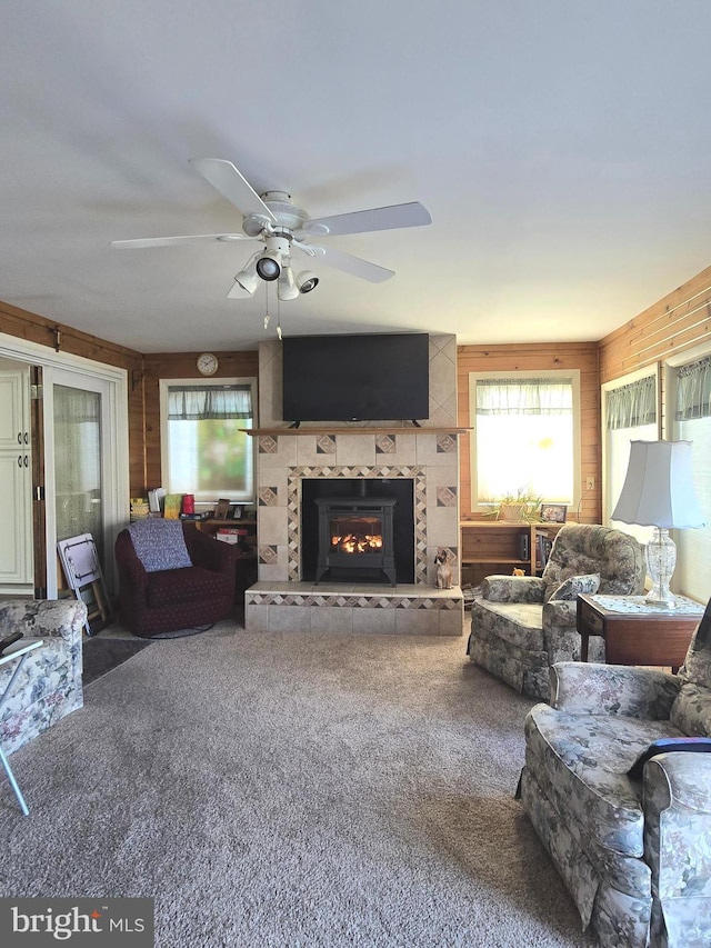 living room featuring a fireplace, a wealth of natural light, ceiling fan, and carpet