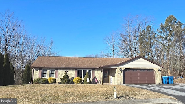 ranch-style home with a garage and a front lawn