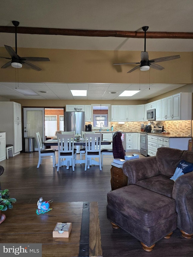 living room with plenty of natural light, dark hardwood / wood-style floors, and ceiling fan