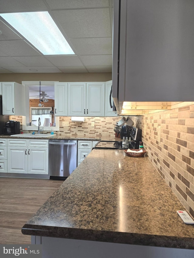 kitchen with white cabinetry, sink, decorative backsplash, and stainless steel dishwasher