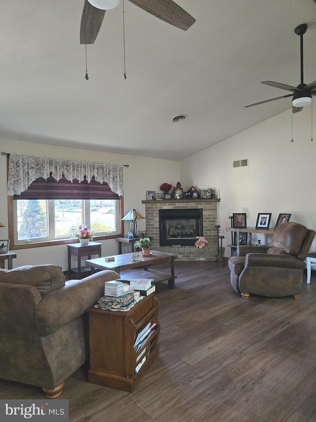 living room with ceiling fan, lofted ceiling, dark hardwood / wood-style floors, and a brick fireplace