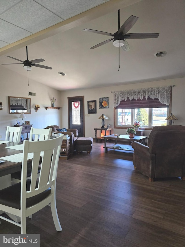 living room with dark wood-type flooring, ceiling fan, and high vaulted ceiling