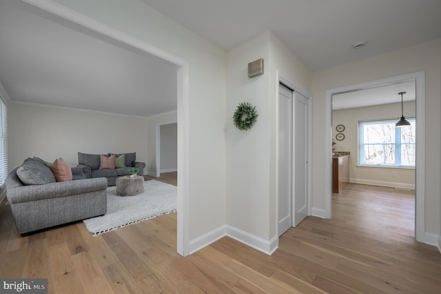 hall with baseboards and light wood-style flooring