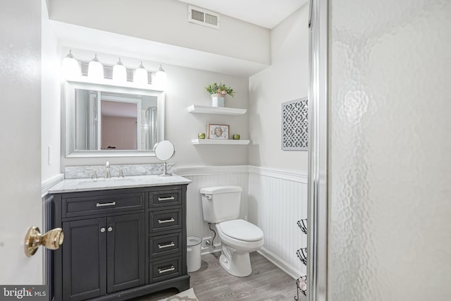 bathroom featuring vanity, wood-type flooring, and toilet