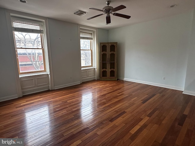 unfurnished room featuring dark wood-type flooring and ceiling fan