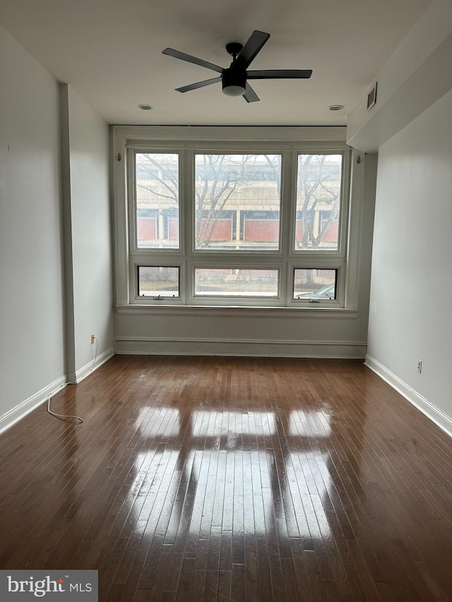 unfurnished room with dark hardwood / wood-style flooring and ceiling fan