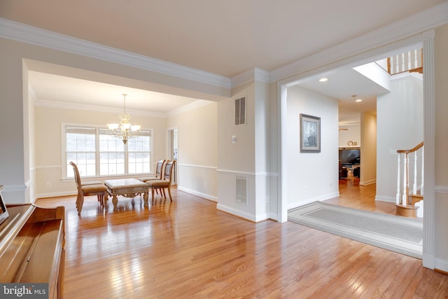 dining area featuring crown molding, an inviting chandelier, and light hardwood / wood-style floors