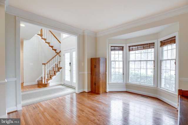 spare room featuring light hardwood / wood-style flooring, crown molding, and french doors