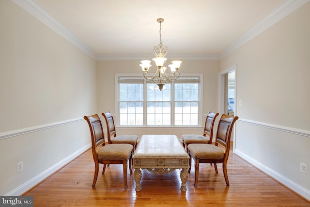 living area featuring light hardwood / wood-style flooring, crown molding, and an inviting chandelier