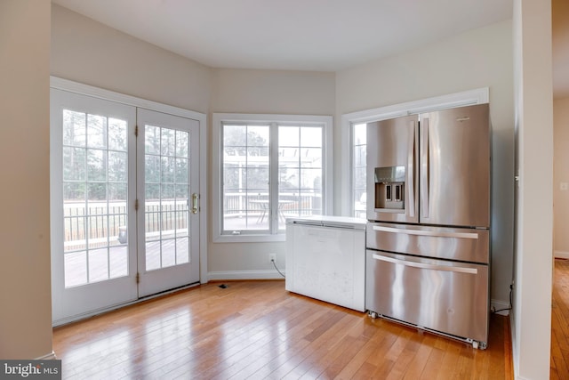 kitchen with light wood-type flooring and stainless steel refrigerator with ice dispenser