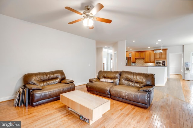 living room featuring light wood-type flooring and ceiling fan