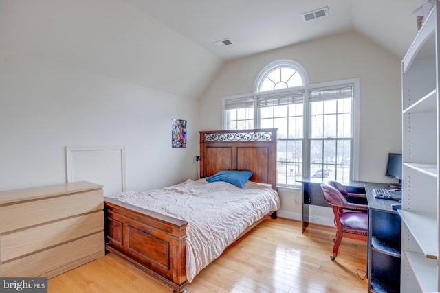 bedroom featuring light hardwood / wood-style floors and vaulted ceiling