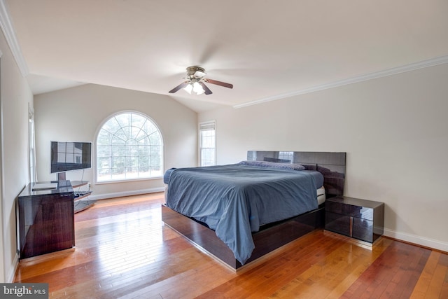 bedroom featuring ceiling fan, light wood-type flooring, crown molding, and lofted ceiling