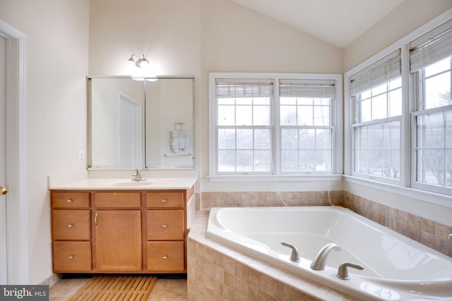 bathroom with vanity, a relaxing tiled tub, tile patterned floors, and lofted ceiling