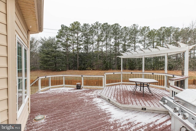 snow covered deck with area for grilling and a pergola