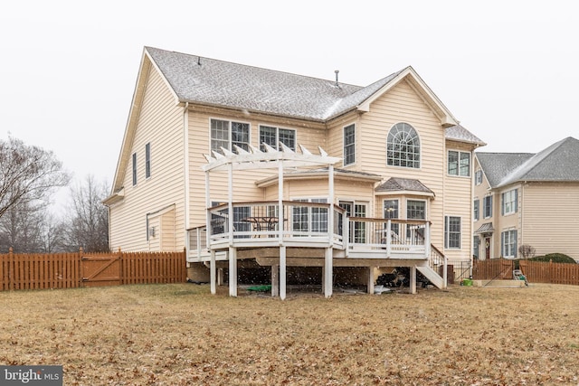 rear view of house with a lawn, a deck, and a pergola