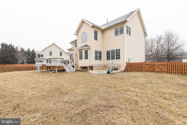 rear view of property featuring a lawn and a wooden deck