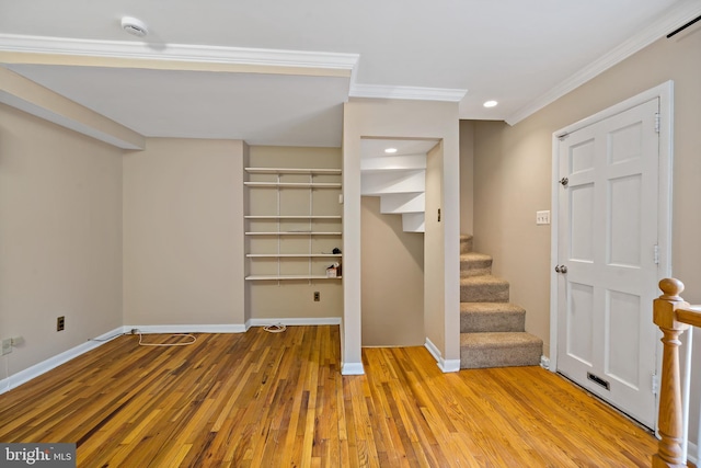 entryway featuring ornamental molding and light hardwood / wood-style flooring