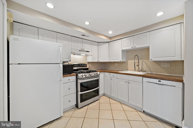 kitchen with white cabinetry, white appliances, sink, and tasteful backsplash