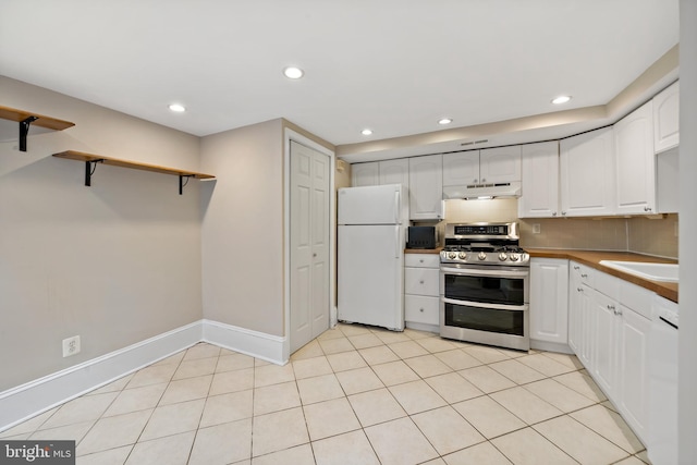 kitchen with sink, white appliances, white cabinets, light tile patterned flooring, and decorative backsplash