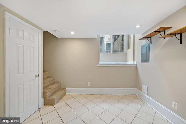 basement featuring light tile patterned flooring and electric panel