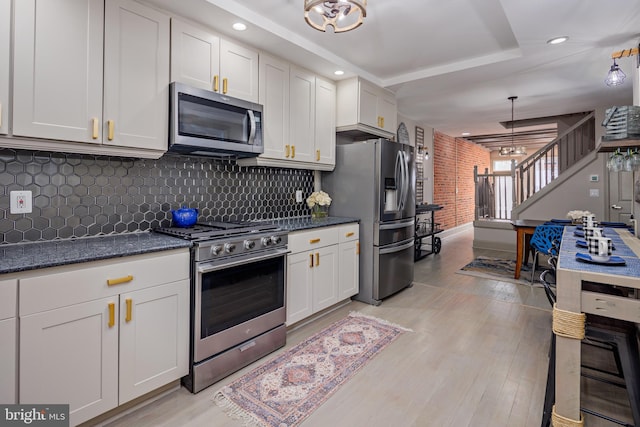 kitchen with tasteful backsplash, light wood-style flooring, white cabinetry, and stainless steel appliances