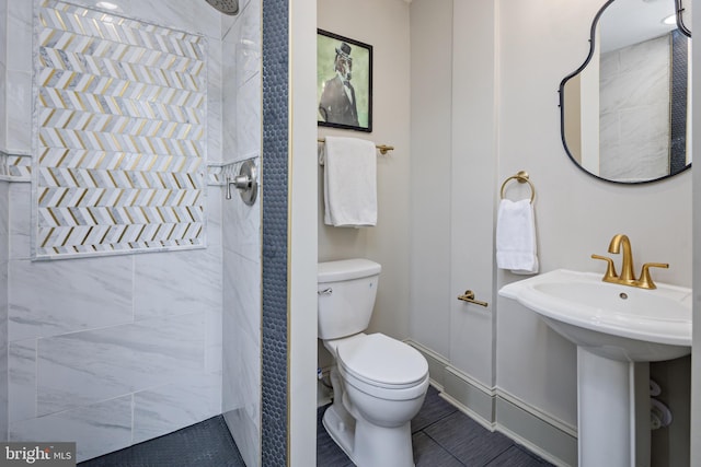 full bathroom featuring a sink, toilet, and baseboards