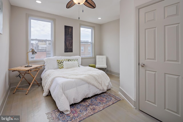 bedroom with baseboards, multiple windows, recessed lighting, and light wood-style floors