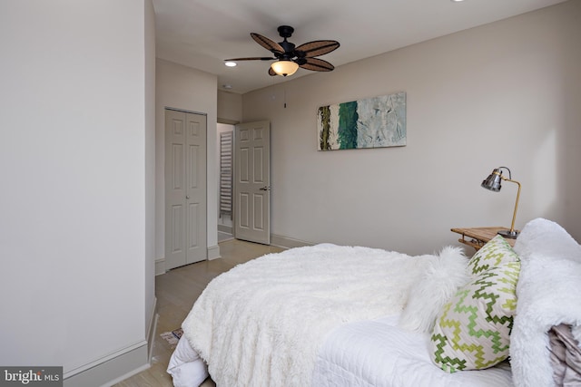 bedroom featuring light wood finished floors, a ceiling fan, baseboards, and a closet