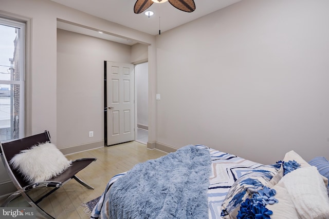 bedroom with light wood-style floors, ceiling fan, and baseboards