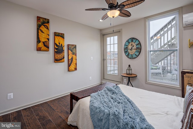 bedroom featuring dark wood finished floors, a ceiling fan, access to outside, a wall mounted air conditioner, and baseboards