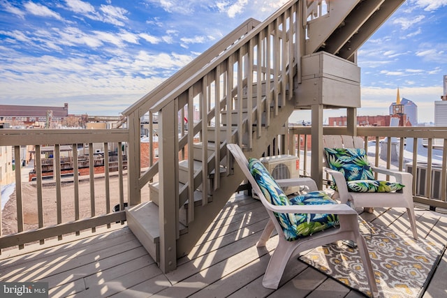 wooden terrace with a view of city and stairway