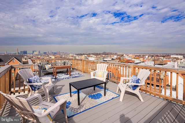 wooden deck featuring a view of city and an outdoor living space