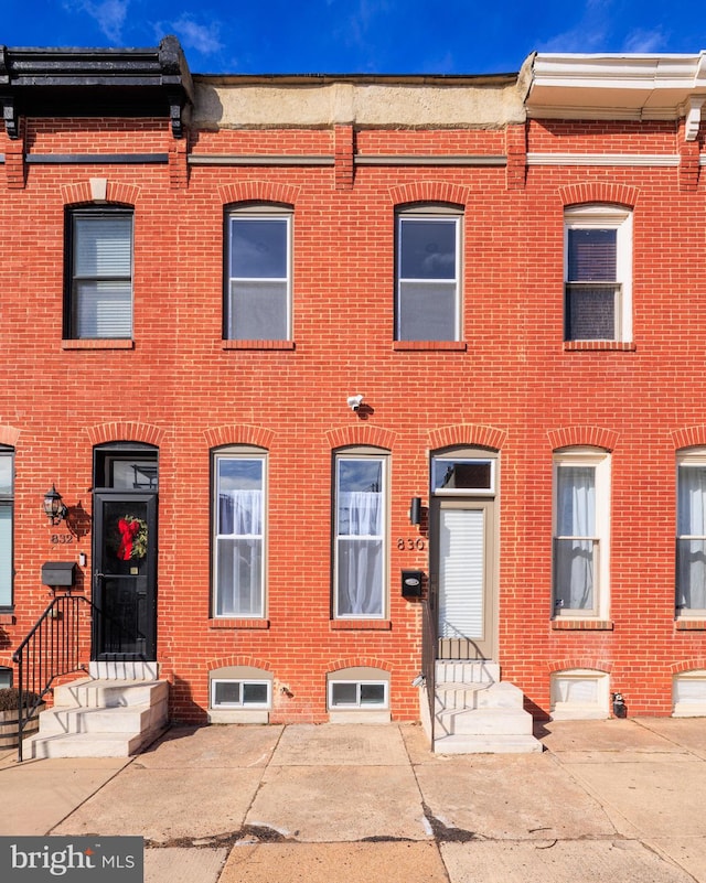 multi unit property with a patio area and brick siding