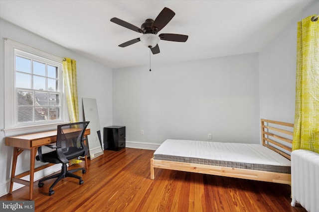 bedroom with hardwood / wood-style flooring and radiator heating unit