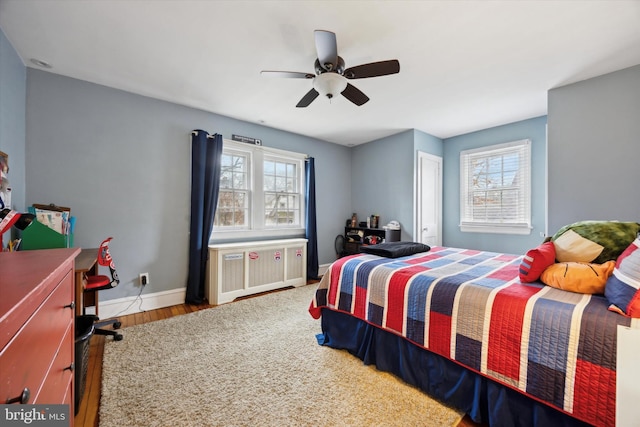 bedroom featuring radiator, hardwood / wood-style floors, and ceiling fan