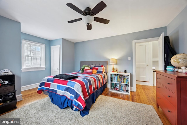 bedroom with ceiling fan, a closet, and light hardwood / wood-style flooring