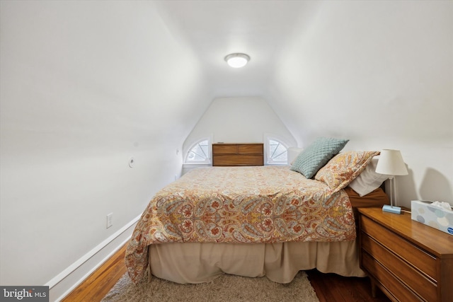 bedroom with hardwood / wood-style flooring and lofted ceiling