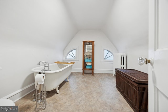 carpeted office space with radiator and vaulted ceiling