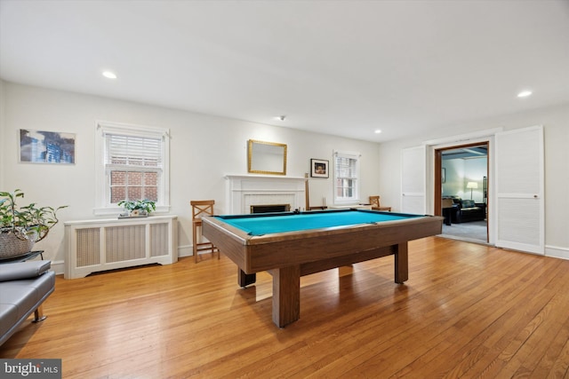 recreation room with light hardwood / wood-style flooring, a fireplace, radiator heating unit, and billiards