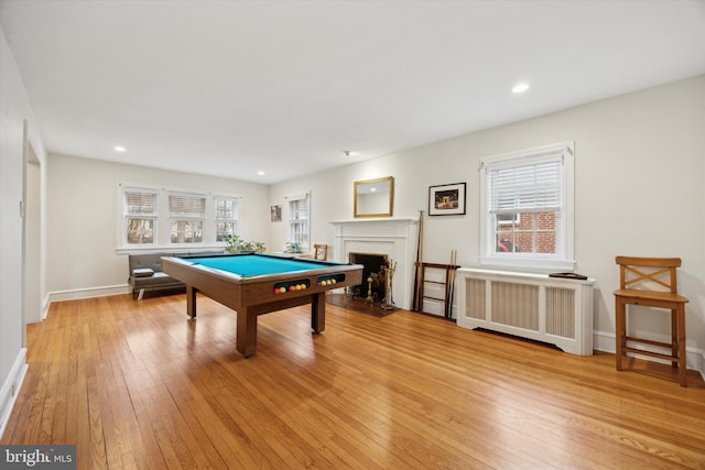 game room featuring light hardwood / wood-style flooring, radiator heating unit, and billiards