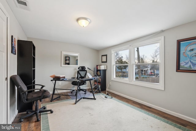 home office with lofted ceiling, visible vents, baseboards, and wood finished floors