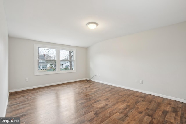 unfurnished room with baseboards and wood finished floors