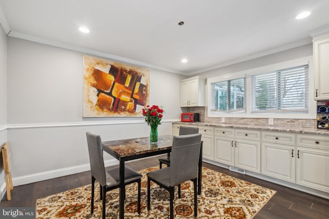 dining room featuring baseboards, dark wood-style flooring, visible vents, and crown molding