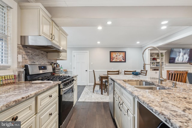 kitchen featuring dark wood-style floors, stainless steel appliances, crown molding, under cabinet range hood, and a sink