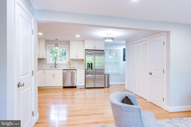 12452 White Horse Rd, Lusby, MD 20657 - kitchen with light wood finished floors, appliances with stainless steel finishes, light countertops, and white cabinetry