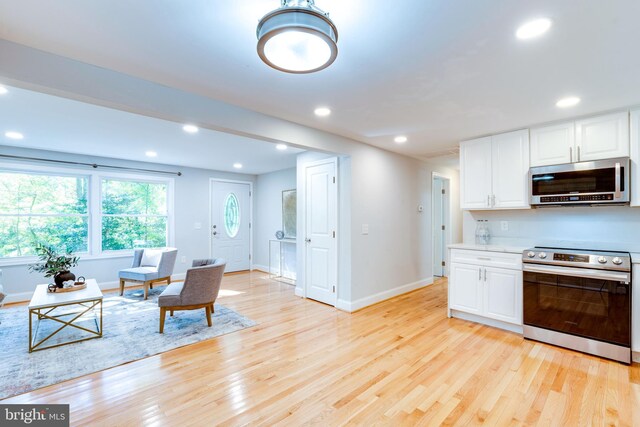12452 White Horse Rd, Lusby, MD 20657 - kitchen with recessed lighting, stainless steel appliances, white cabinets, and light wood finished floors